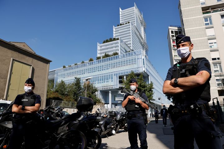 Police officers stand guard outside the Paris courthouse on Sept. 2, 2020, on the opening day of the trial of 14 suspected accomplices in Charlie Hebdo jihadist killings.
