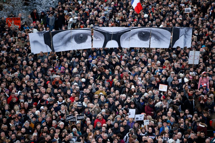 People hold panels to create the eyes of late Charlie Hebdo editor Stephane Charbonnier, known as "Charb," as hundreds of thousands of French citizens take part in a solidarity march in the streets of Paris on Jan. 11, 2015.