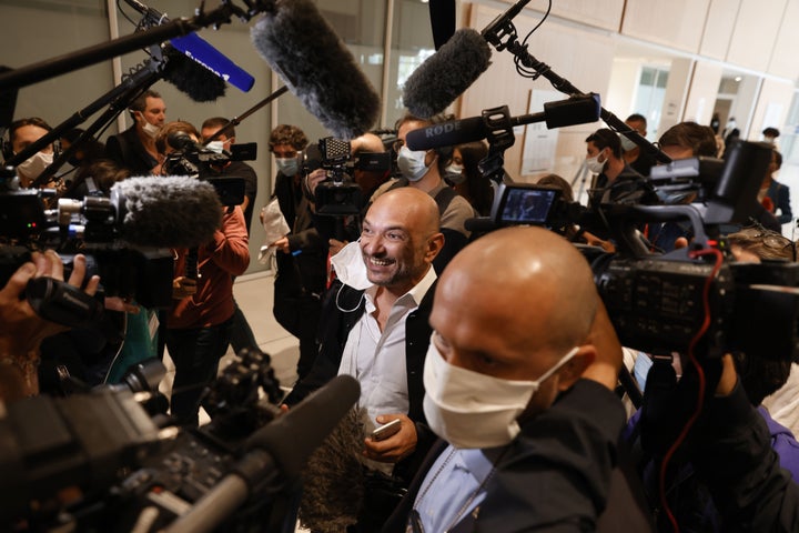 Charlie Hebdo's lawyer Richard Malka answers questions from reporters as he arrives at the Paris courthouse.