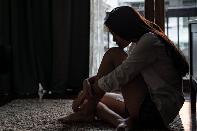 Selective focus lonely young Asian woman sitting on the bedroom floor near the balcony.  Depression Sadness ...