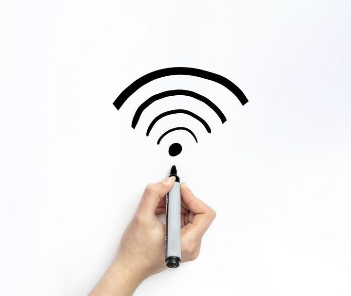 Hand drawing a wifi signal on white page with marker