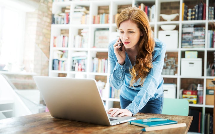 Woman using smartphone and laptop