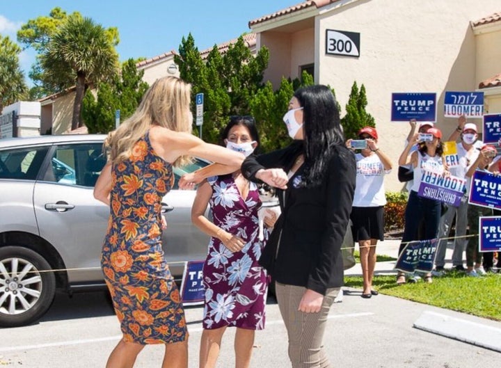 Trump, left, bumps elbows with Loomer at the GOP event.