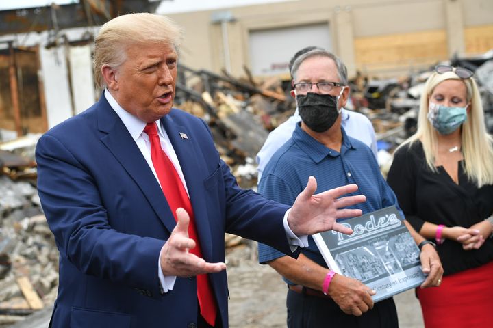 President Donald Trump, flanked by John Rode III, the former owner of Rode’s Camera Shop, speaks with the press during a tour of an area damaged amid demonstrations in Kenosha, Wisconsin.