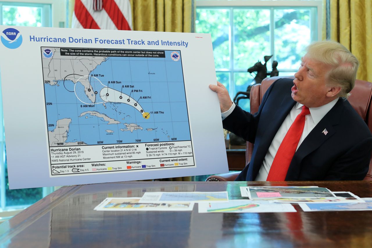 In the Oval Office of the White House, President Donald Trump holds a chart showing the original projected track of Hurricane Dorian that appears to have been extended with a black line to include parts of the Florida panhandle and Alabama on Sept. 4, 2019. 
