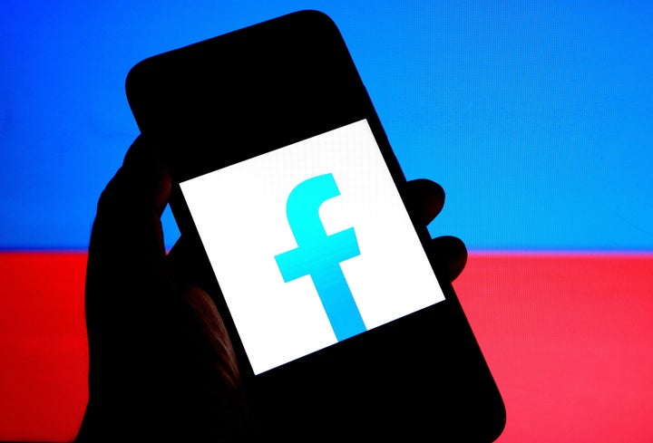 A photo illustration of the Facebook logo on a smartphone.