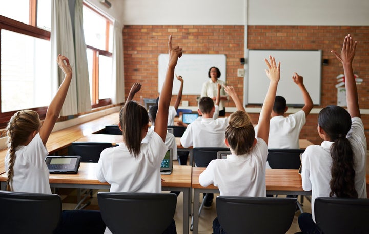 School teacher teaching students in class, working with tablets