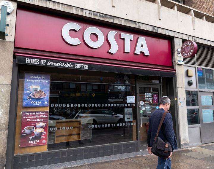 A man walks past a closed Costa coffee shop in London.