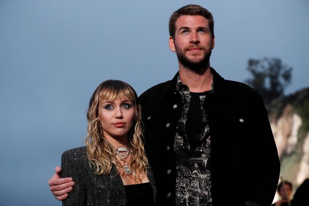 Miley Cyrus and Liam Hemsworth, then married, pose at the Saint Laurent Men’s Spring/Summer 2020 fashion show on June 6, 2019.