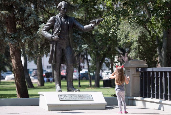 A little girl stops to look at a statue of John A. Macdonald in Victoria Park in Regina on August, 22, 2018. THE CANADIAN PRESS J