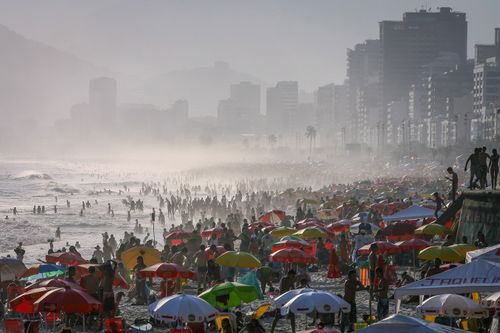 Thousands of people flock to Ipanema beach in Rio de Janeiro. Beach access was banned in March 2020 due to the pandemic and still remains so, with some exceptions. Despite this, thousands of people still visit Rios beaches daily. Above: Oct. 26, 2008 | Below: July 23, 2020