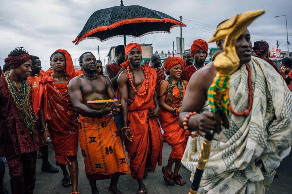 Tribal chiefs in Ghana traditionally have an entourage that, among other things, uses an umbrella to shield the chief from the sun. Here, a chief of the Ga tribe visits the Chale Wote Street Art Festival in Accra in 2015. Below, Chief Nana Munko Eku VIII of the Fante tribe visits a wedding in Cape Coast in 2020, where he and his entourage wear masks. Above: Aug. 23, 2015 | Below: Aug. 8, 2020