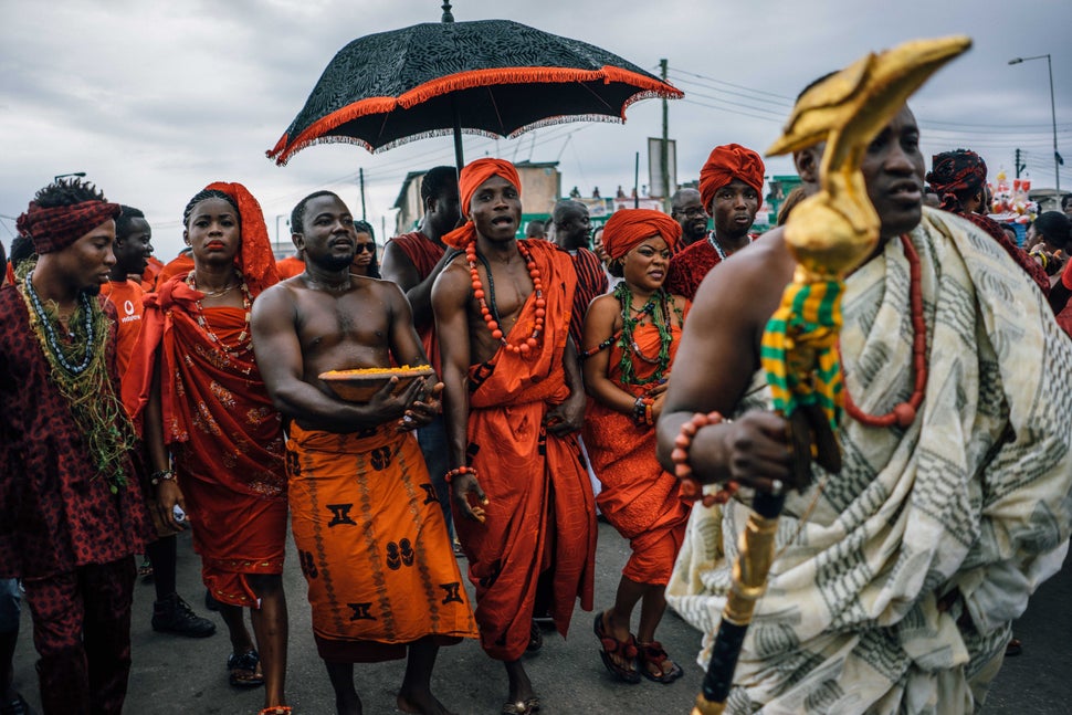 Tribal chiefs in Ghana traditionally have an entourage that, among other things, uses an umbrella to shield the chief from the sun. Here, a chief of the Ga tribe visits the Chale Wote Street Art Festival in Accra in 2015. Below, Chief Nana Munko Eku VIII of the Fante tribe visits a wedding in Cape Coast in 2020, where he and his entourage wear masks. Above: Aug. 23, 2015&nbsp;| Below: Aug. 8, 2020