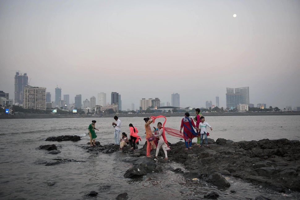 People on the rocks by the Haji Ali Dargah mosque in Mumbai. Built on an islet in 1431 to house the shroud of Pir Haji Ali Shah Bukhari, the mosque normally hosts more than 100,000 visitors each week. However, with the ongoing coastal road construction around the mosque, a large portion of the rocky bed surrounding the mosque is submerged and likely to sink further. Above: Feb. 9, 2017 |&nbsp; Below: July 29, 2020