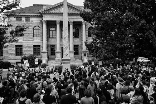 The locally nicknamed Lost Cause Confederate monument in Decatur Square in Atlanta was removed in June 2020 following years of protest. A hologram image of George Floyd, who was murdered by police in Minneapolis in May 2020, temporarily took the place of the Confederate monument. Floyd's murder sparked international waves of protests. Above: Sept. 9, 2017 | Below: July 29, 2020