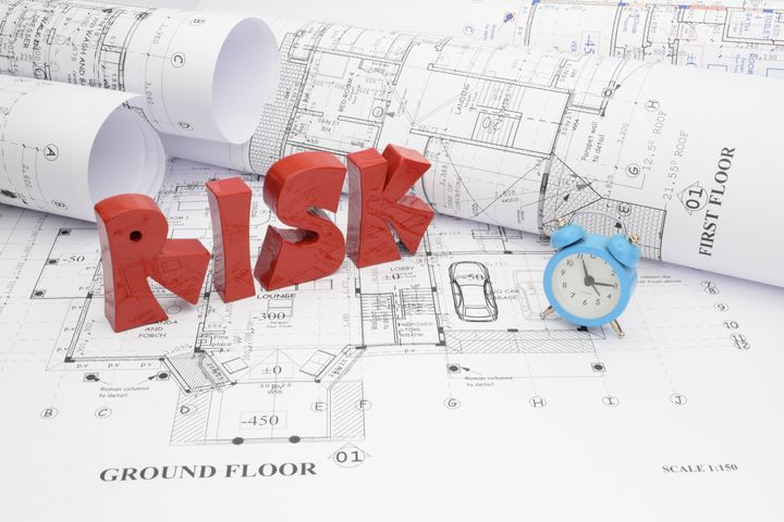 Blueprints and risk of passing the deadline in the construction project.