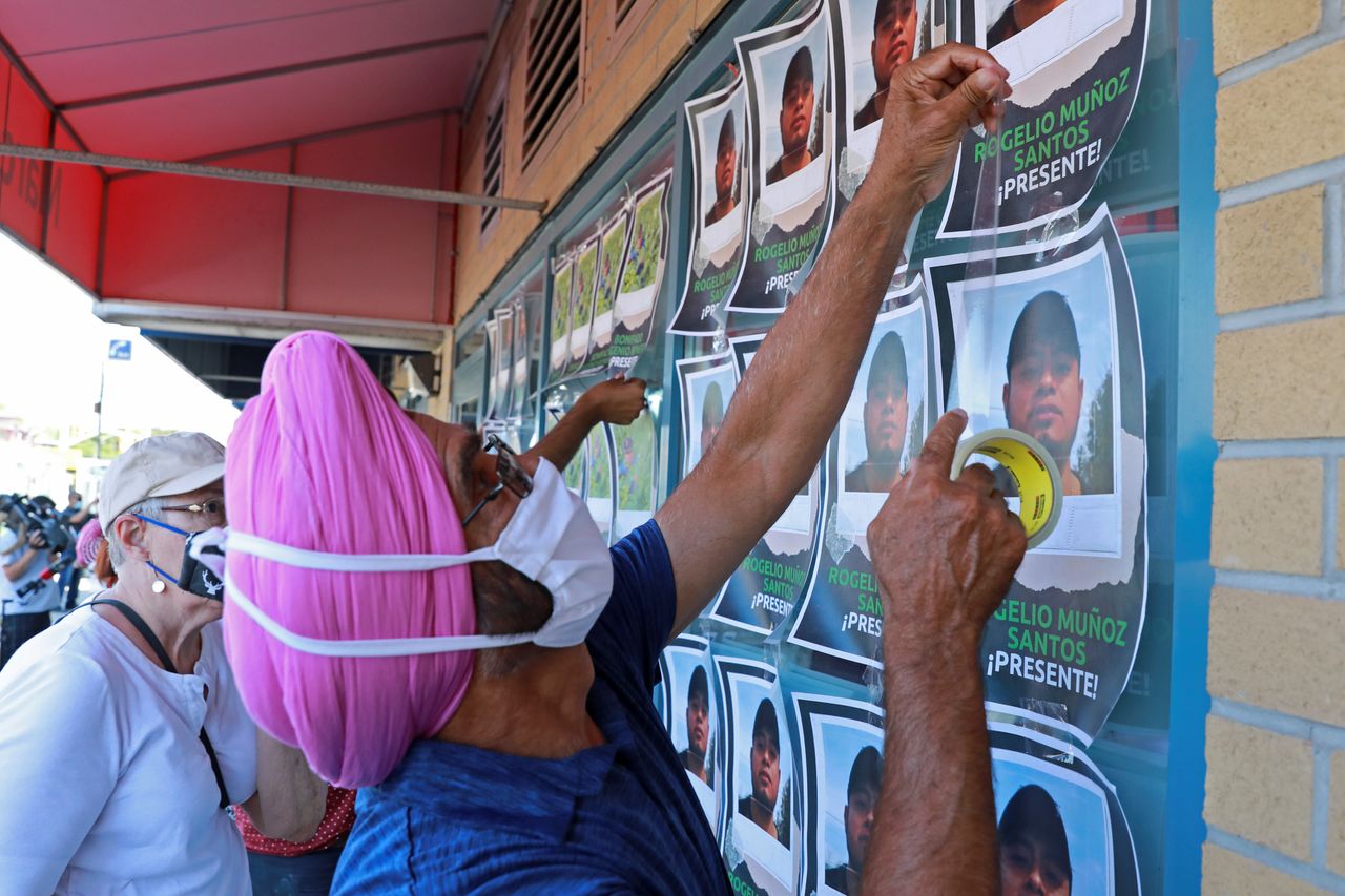 Supporters tape photographs of migrant worker Rogelio Munoz Santos, who died from coronavirus disease (COVID-19), during a pro-immigration rally by migrants, refugees and undocumented workers outside the office of Canada's Immigration Minister Marco Mendicino in Toronto on July 4, 2020.