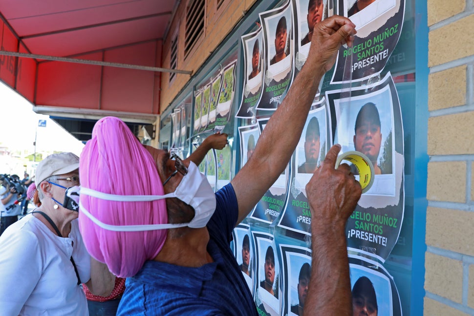 Supporters tape photographs of migrant worker Rogelio Munoz Santos, who died from coronavirus disease (COVID-19), during a pr