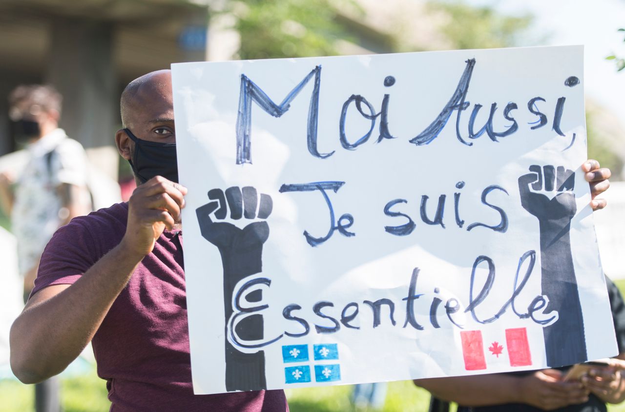People take part in a protest outside Prime Minister Justin Trudeau's constituency office in Montreal on Aug. 15, 2020, where they called on the government to give permanent residency status to all migrant workers and asylum seekers.