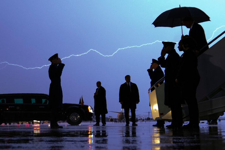 Lightning streaks across the sky as President Donald Trump walks from Air Force One carrying an umbrella as he arrives at Andrews Air Force Base in Maryland after a campaign rally in late August. A poll of subscribers to the Military Times shows him trailing Democrat Joe Biden. 