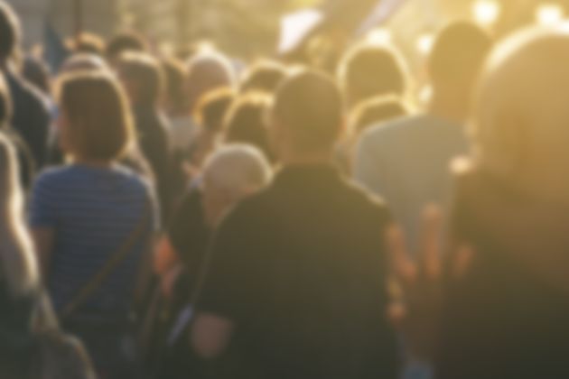 Unfocused crowd attending a political meeting, a large group of unrecognizable people as an audience of politicians ...