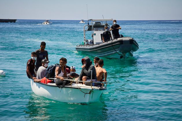 LAMPEDUSA, ITALY - AUGUST 28: Migrants from Tunisia dock their ship in a port on August 28, 2020 in Lampedusa, ...