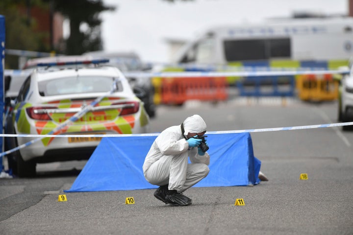 A police forensics officer taking photographs in Irving Street, in Birmingham after a number of people were stabbed in the ci