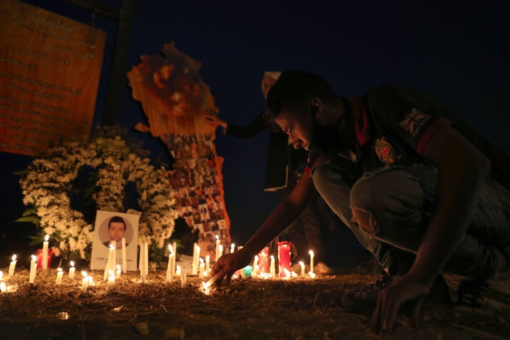 A man lights a candle near the seaport of Beirut, as he mark one month since the devastating Aug. 4 explosion in Beirut , Lebanon, Friday, Sept. 4, 2020. (AP Photo/Bilal Hussein)