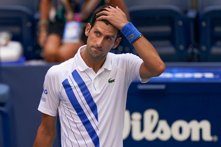 Novak Djokovic, of Serbia, reacts after inadvertently hitting a line judge with a ball after hitting it in reaction to losing a point against Pablo Carreno Busta, of Spain, during the fourth round of the US Open tennis championships, Sunday, Sept. 6, 2020, in New York. Djokovic defaulted the match. (AP Photo/Seth Wenig)