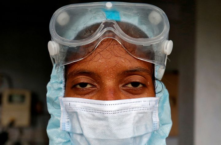 A healthcare worker wearing protective gear after she took swabs from residents for a rapid antigen test at a residential apartment in Ahmedabad, India, July 23, 2020. 
