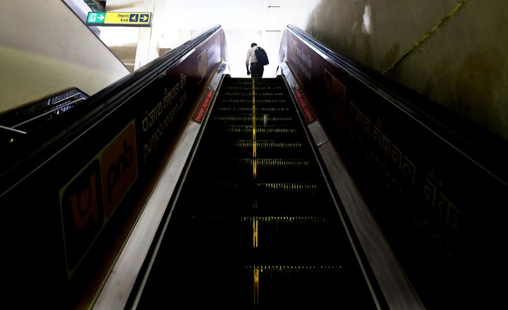 A commuter takes an escalator at a metro train station in Gurugram India, Monday, September 7, 2020.