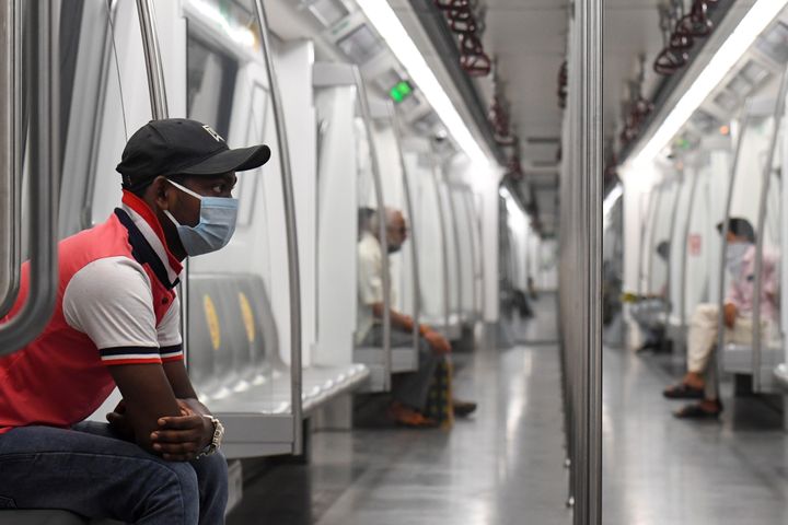 Commuters sit in a carriage of a Yellow Line train after Delhi Metro resumed services.