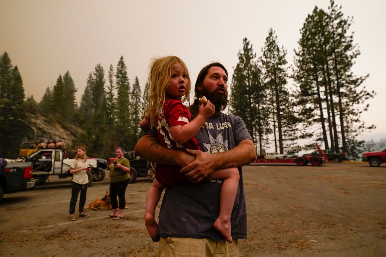 Jeremy Hedrick holds his son Jeep as smoke from the Creek Fire fills the air on Monday.