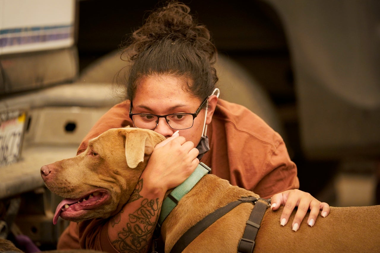 Inelva Gonzalez, of Armona, Calif. kisses her dog SayD in a marina where campers were being held due to impassable roads.