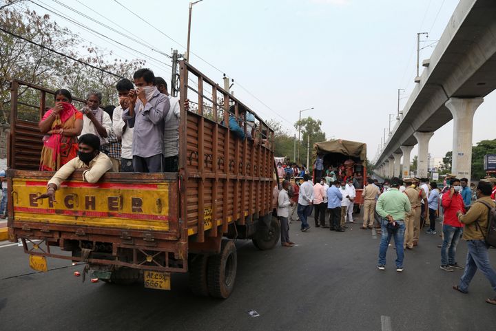 Indian migrants from Andhra Pradesh state, who were stopped while attempting to return to their native villages on foot, are moved on trucks to a government facility during lockdown to prevent the spread of new coronavirus in Hyderabad, India, Tuesday, April 14, 2020. Indian Prime Minister Narendra Modi on Tuesday extended the world's largest coronavirus lockdown to head off the epidemic's peak, with officials racing to make up for lost time. (AP Photo/Mahesh Kumar A.)
