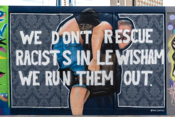 Lionel Stanhope's artwork in Lewisham, based on a photo taken by Reuters photographer Dylan Martinez of a Black Lives Matter protester Patrick Hutchinson carrying Bryn Male outside the Southbank Centre. It was painted over with the words: "We don't rescue racists in Lewisham we run the out".