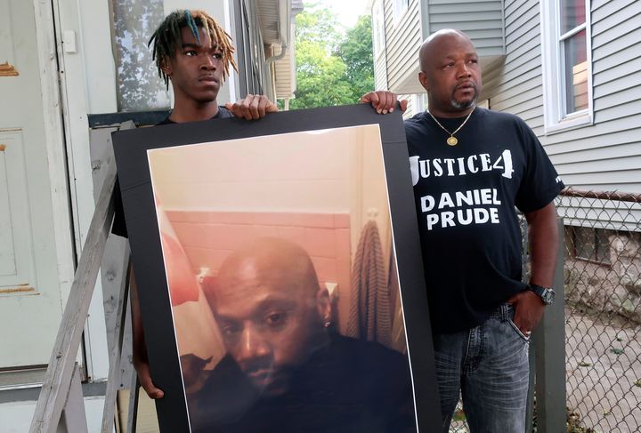 Joe Prude, uncle of Daniel Prude, right, and Daniel's nephew Armin, stand with a picture of Daniel Prude in Rochester, N.Y., on Thursday, Sept. 3, 2020. (AP Photo/Ted Shaffrey)