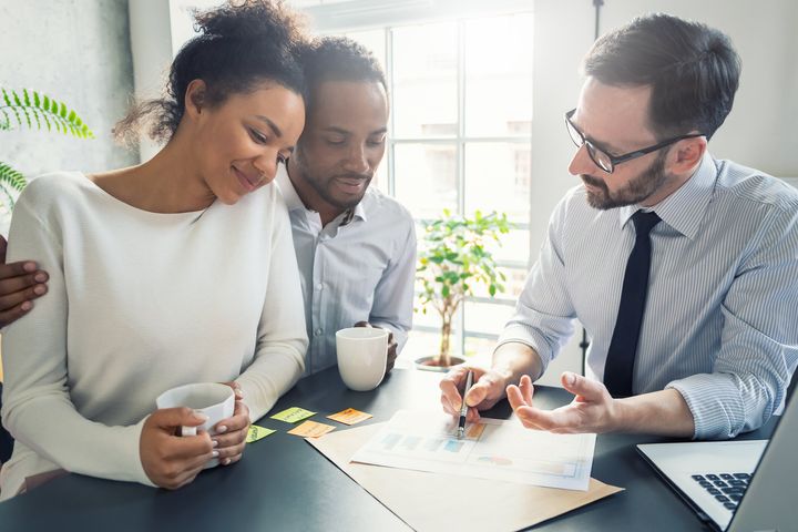 A couple goes over their finances with a mortgage professional in this undated stock photo. Refinancing your mortgage will allow you to access equity in your home, which is useful if you need cash.