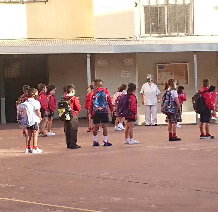 En el patio los niños han formado filas manteniendo la distancia de seguridad entre ellos.