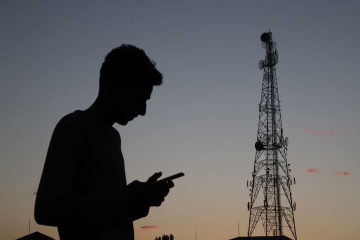 Mobile Phone towers are seen as a boy uses a Cell Phone in Sopore town of District Baramulla, Jammu and Kashmir, India on 8 September 2020. Barring two districts, 4G internet ban extended in J&K till Sep 30 (Photo by Nasir Kachroo/NurPhoto via Getty Images)