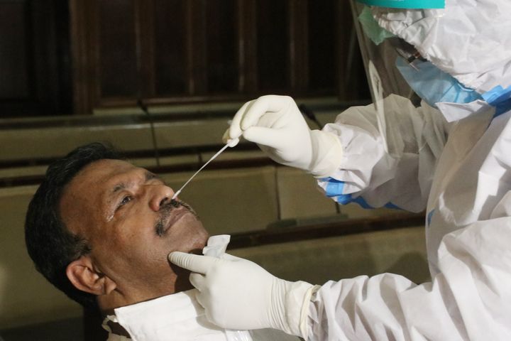 A health worker collects a swab sample from West Bengal Minister Firad Hakim to test for the coronavirus at the West Bengal Legislative Assembly house in Kolkata, India on September 08,2020.