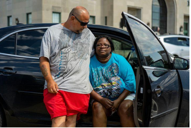 16 août 2020, David Frantz et Pamela Elliott attendent devant un abri aménagé par la Croix- Rouge américaine au Veterans Memorial Building de Cedar Rapids. Leur appartement a été détruit par un phénomène météorologique rare connu sous le nom de « derecho », qui a soufflé le toit de leur immeuble. Pamela setrouvait à l