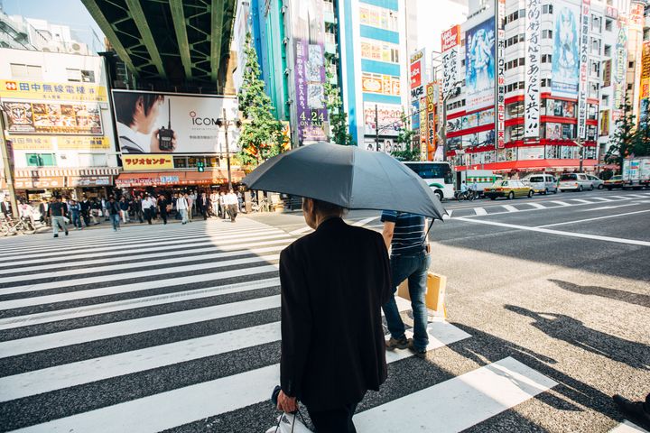 日傘をさす男性のイメージ写真