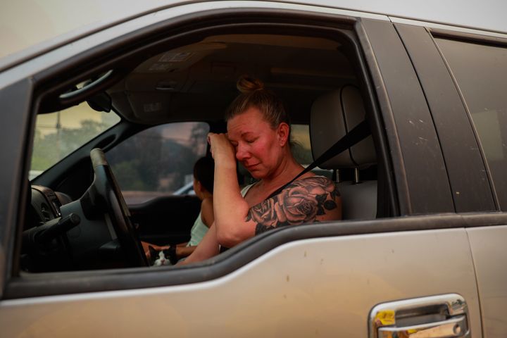 Gina Santos cries in her car after evacuating due to the LNU Lightning Complex Fire in Vacaville, California, on Aug. 19, 2020. She moved to her "dream house" several months ago and was distraught that it might have burned down.