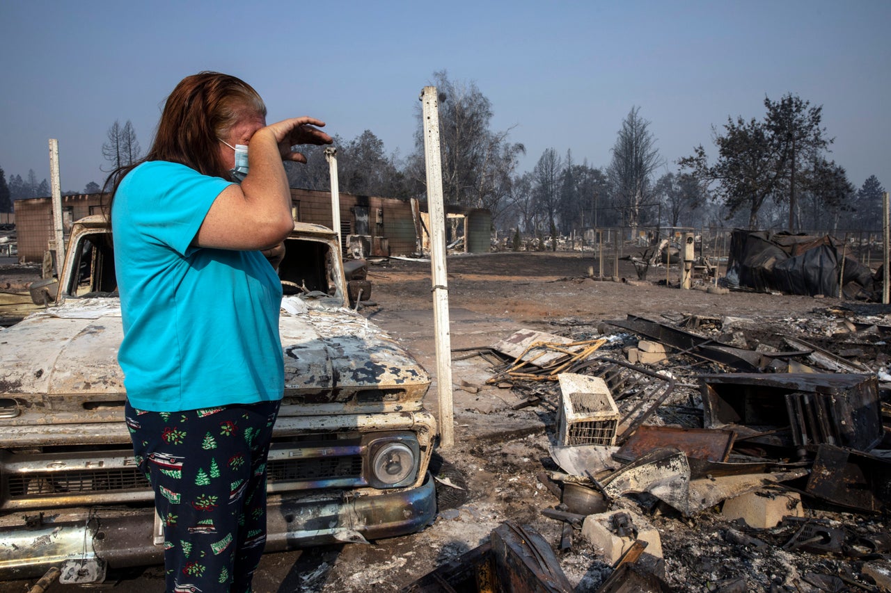 Heather Marshall stands amid what remains of her home at Coleman Creek Estates mobile home park in Phoenix, Oregon, on Thursday. The area was destroyed when a wildfire swept through on Tuesday. The Marshalls had lived at the park for 21 years.