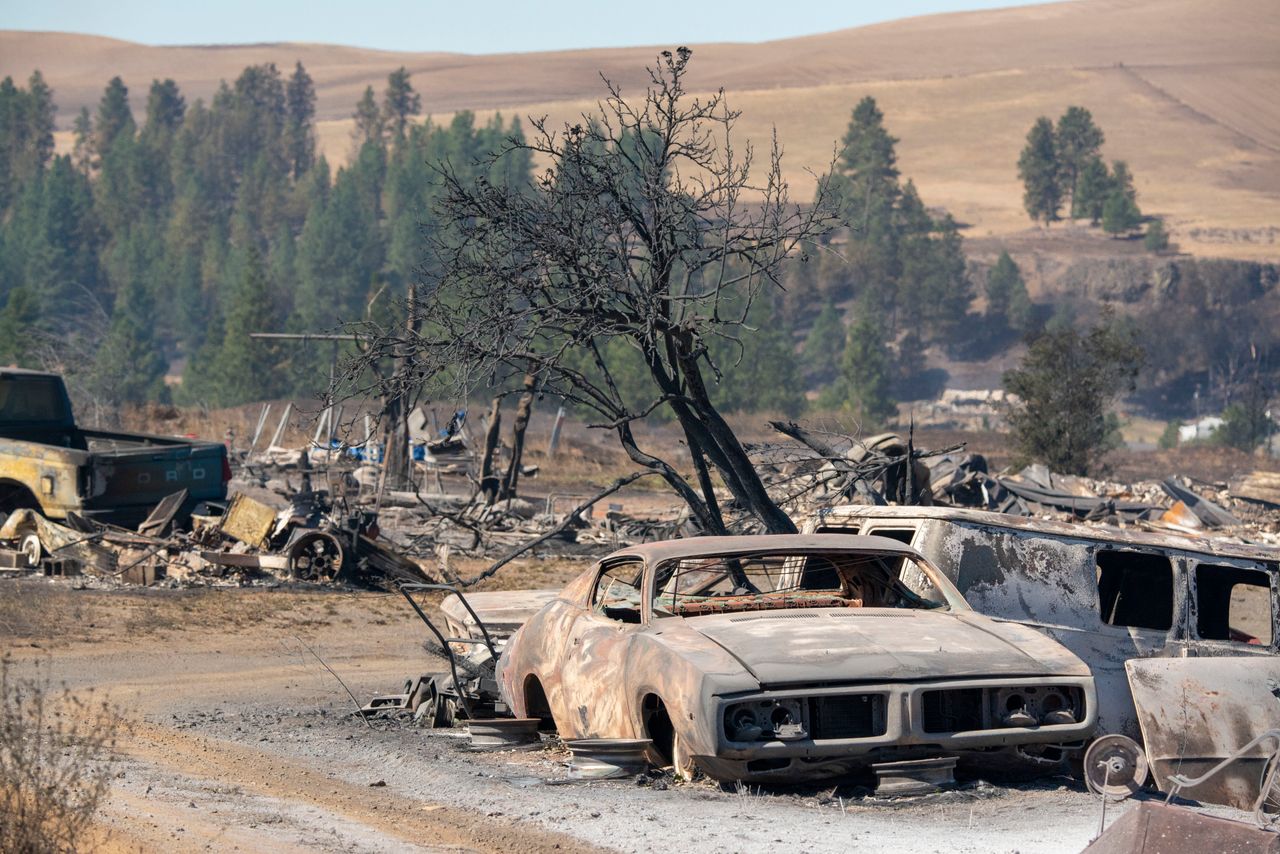 Vehicles are destroyed by a wildfire that swiftly moved through Maldin, Washington, on Tuesday.