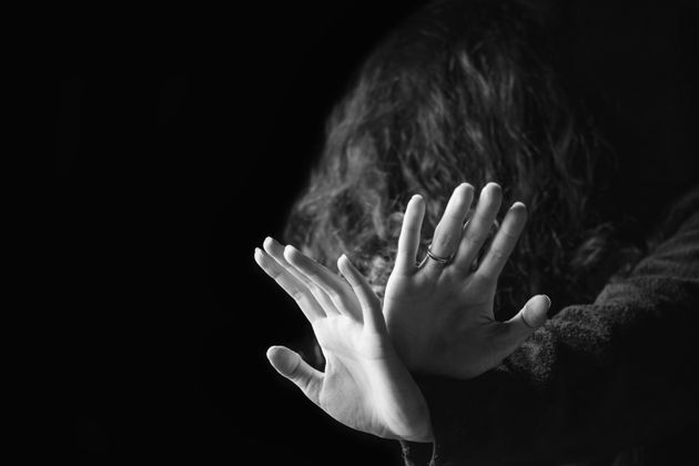 Concept of violence against women.  Black And White Portrait Of Scared And Desperate Woman, Focus On White Background.