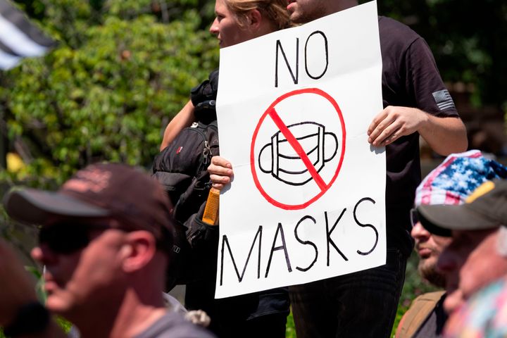 An anti-mask protester holds up a sign in front of the Ohio Statehouse during a protest in July.
