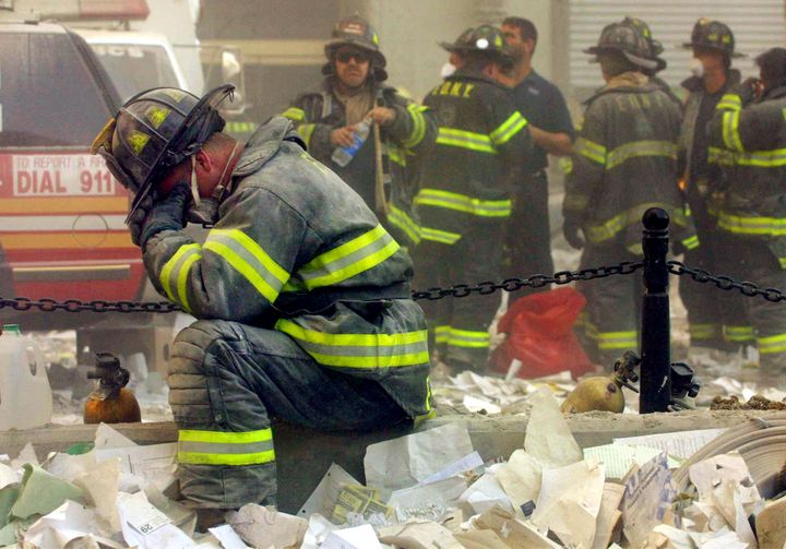 A firefighter bows in grief after the World Trade Center buildings collapsed on Sept. 11, 2001.