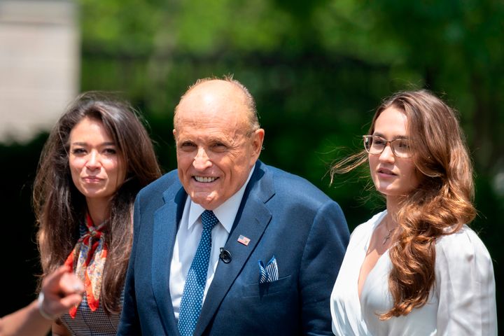 Rudy Giuliani, President Donald Trump's personal attorney, walks with his aide Christianne Allen (right) and One America News Network's Chanel Rion on July 1 after speaking at the White House.